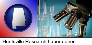 a microscope and glassware in a research laboratory in Huntsville, AL