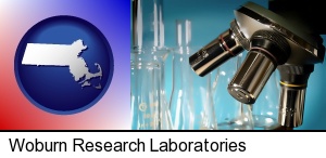 a microscope and glassware in a research laboratory in Woburn, MA