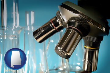 a microscope and glassware in a research laboratory - with Alabama icon