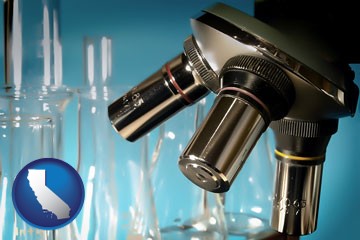 a microscope and glassware in a research laboratory - with California icon