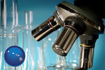 a microscope and glassware in a research laboratory - with Hawaii icon