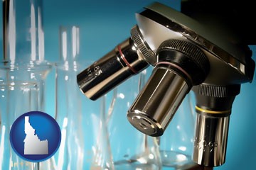 a microscope and glassware in a research laboratory - with Idaho icon
