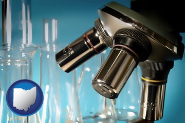 a microscope and glassware in a research laboratory - with Ohio icon