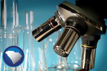 a microscope and glassware in a research laboratory - with South Carolina icon