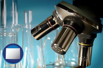 a microscope and glassware in a research laboratory - with Wyoming icon