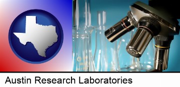 a microscope and glassware in a research laboratory in Austin, TX