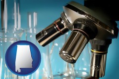 alabama map icon and a microscope and glassware in a research laboratory