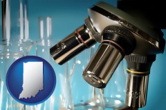 a microscope and glassware in a research laboratory - with IN icon