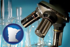minnesota map icon and a microscope and glassware in a research laboratory
