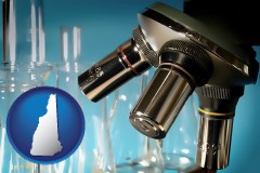 new-hampshire map icon and a microscope and glassware in a research laboratory