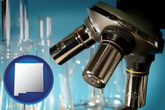 new-mexico map icon and a microscope and glassware in a research laboratory