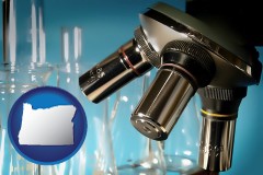 oregon map icon and a microscope and glassware in a research laboratory